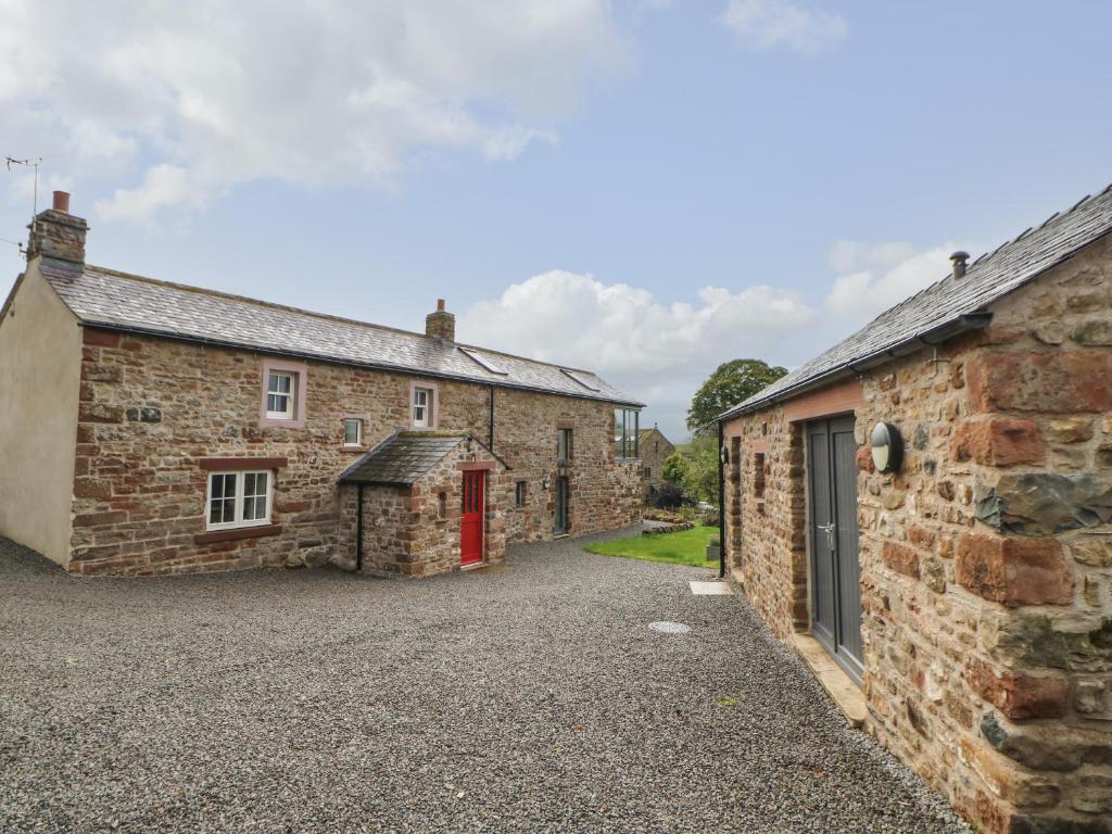 a row of stone cottages with a red door at Brackenber House in Hilton