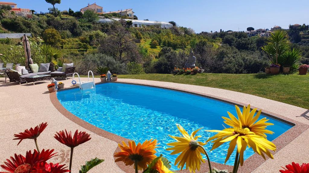 ein Pool mit Blumen im Hof in der Unterkunft Studio-mezzanine dans villa in Cagnes-sur-Mer