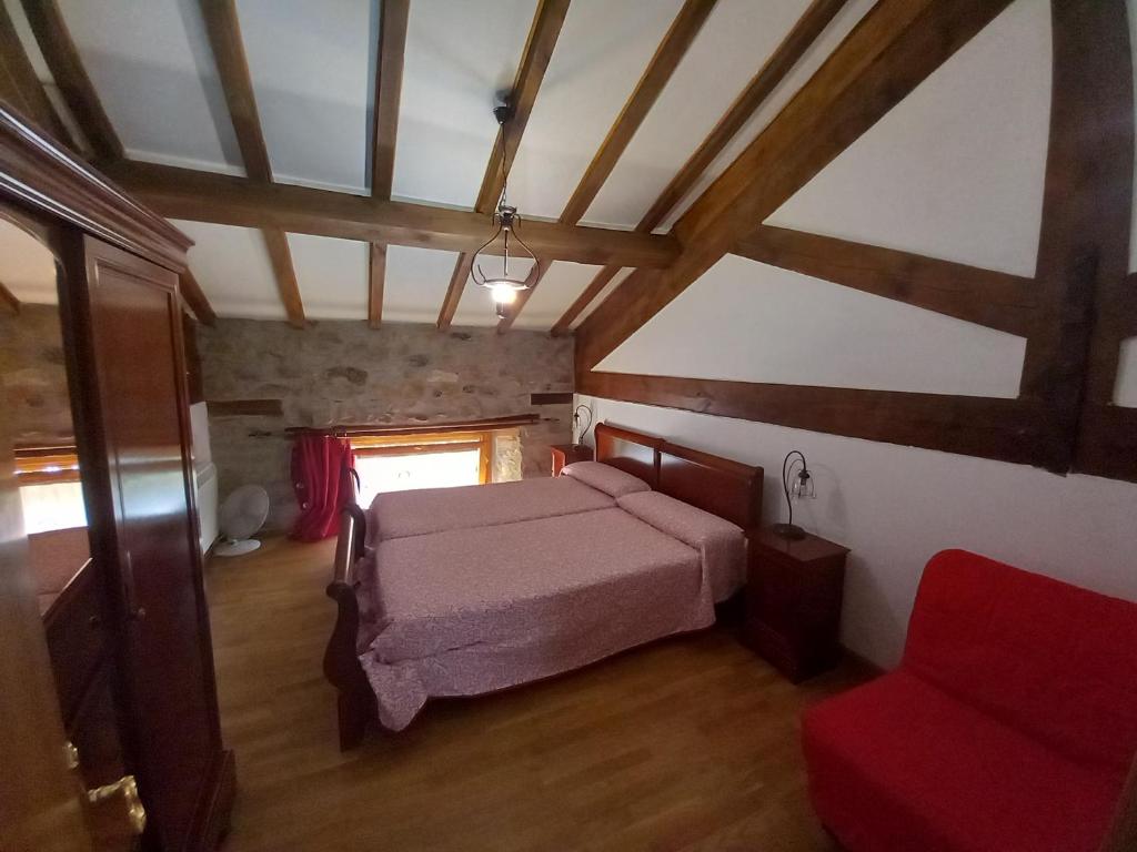 una camera con letto e sedia rossa di Errotazar apartamento rural I ad Alsasua