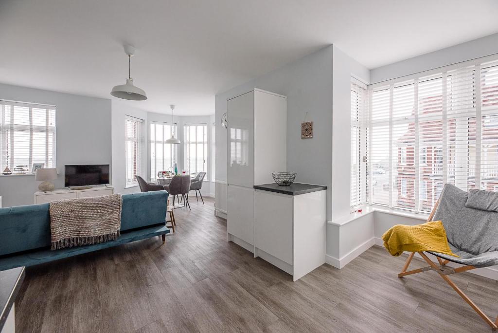 a living room with a couch and a tv and some windows at 4 Buregate House in Felixstowe