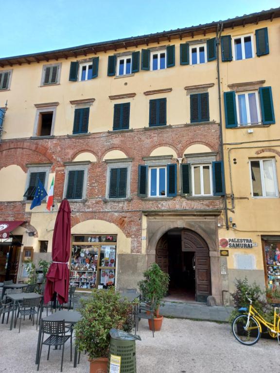 een groot gebouw met tafels en stoelen ervoor bij San Francesco in Lucca