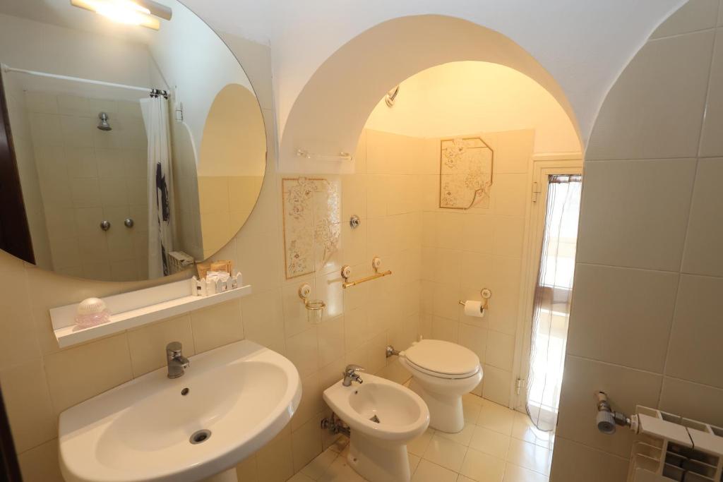 een badkamer met een wastafel, een toilet en een spiegel bij Relax nel Borgo,La Fontana in Campagnano di Roma