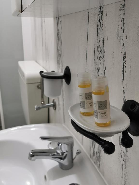 a bathroom sink with two bottles of moisturizers on a shelf at Lo Nardo Accommodation in Lipari