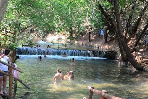熱河市的住宿－APARTAMENTO ÁGUAS DA SERRA - 005b，一群人在带瀑布的游泳池里