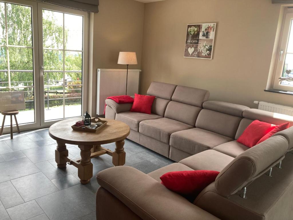 ein Wohnzimmer mit einem Sofa und einem Tisch in der Unterkunft Au Pré Bonheur in Houyet