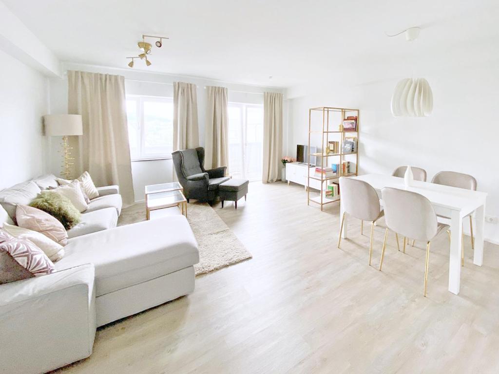 a white living room with a white couch and a table at Fuchsbau unterm Krönchen in Siegen