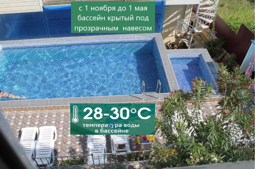 um sinal em frente a uma piscina com cadeiras em Dyadya Styopa em Adler
