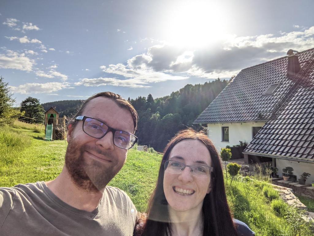 un hombre y una mujer parados frente a una casa en Ferienwohnung Mühl - einfach wohlfühlen en Marienberg