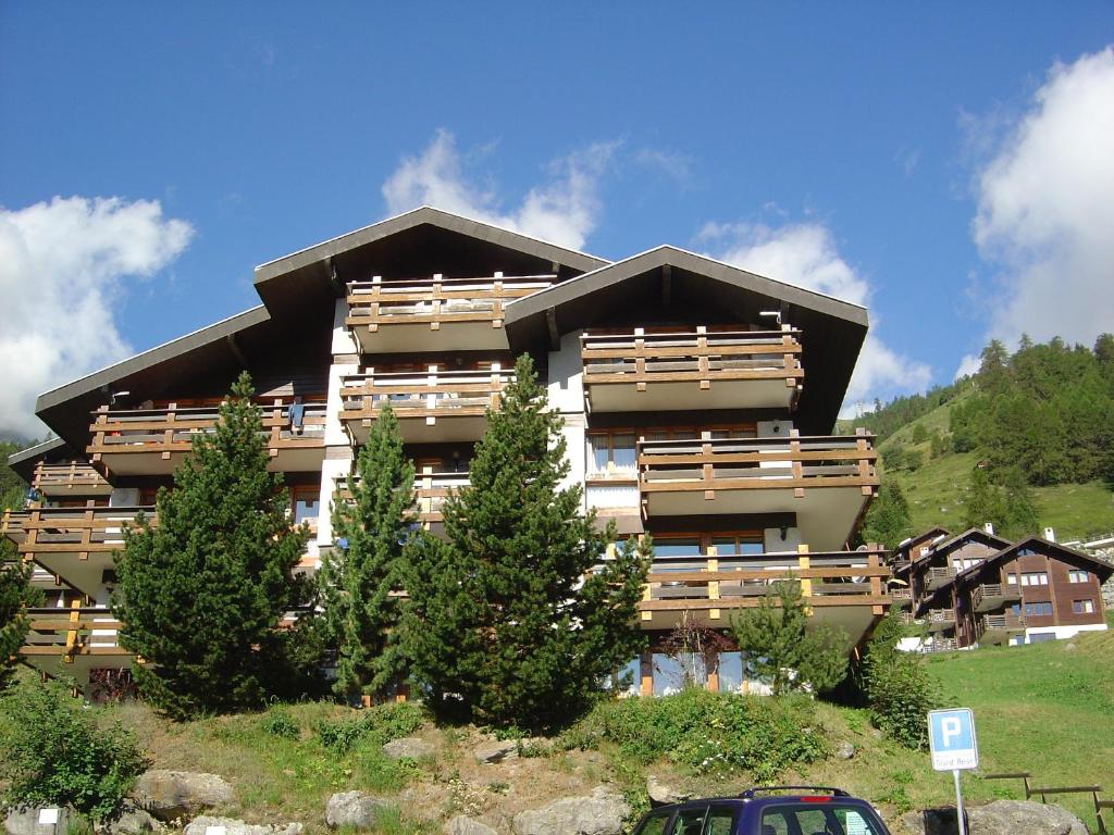 ein großes Gebäude mit Bäumen davor in der Unterkunft Apartments Grand Bisse in Grimentz