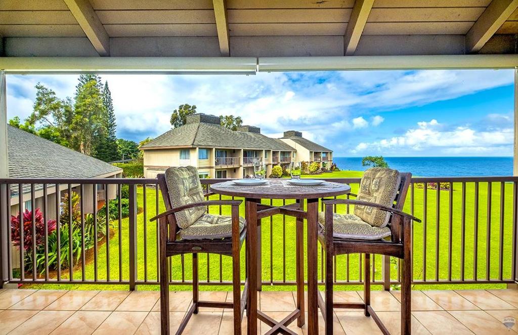 a table and chairs on a balcony with a view of the ocean at Pali Ke Kua #241 in Princeville