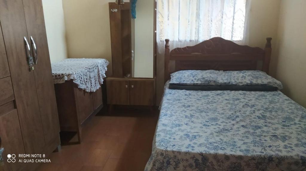 a small bedroom with a bed and a dresser at Casa de Temporada Serra da Canastra - São Roque de Minas in São Roque de Minas