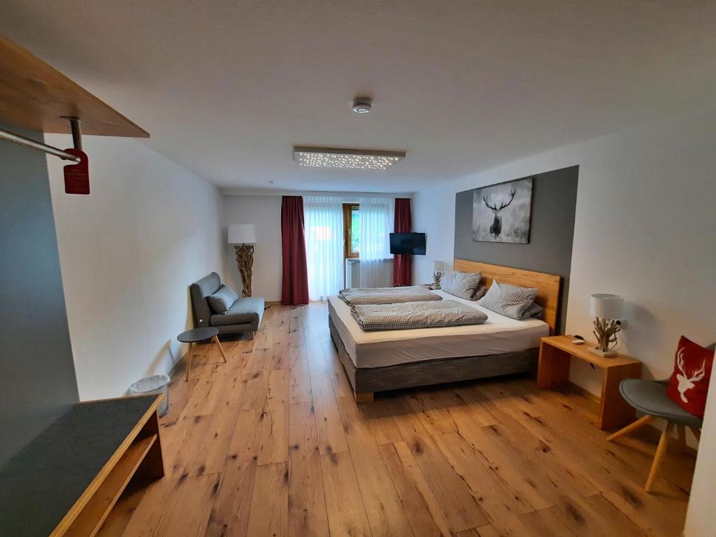ein Schlafzimmer mit einem Bett und ein Wohnzimmer in der Unterkunft Landhotel Albrecht in Missen-Wilhams