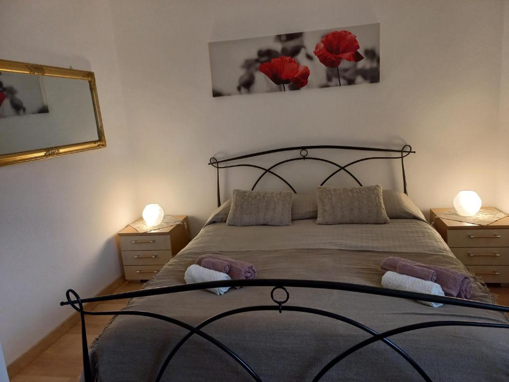 a bedroom with a bed with red flowers on the wall at La Maison de Joanna 2 in Châtillon