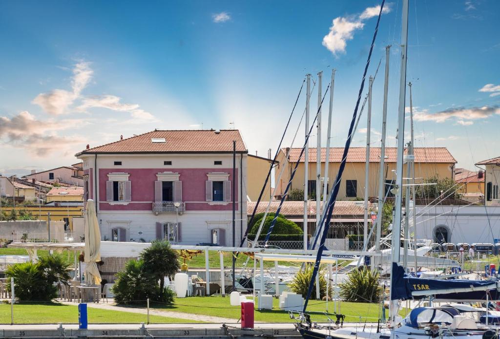 a marina with boats docked in front of a pink house at Villino Ermione in Marina di Pisa