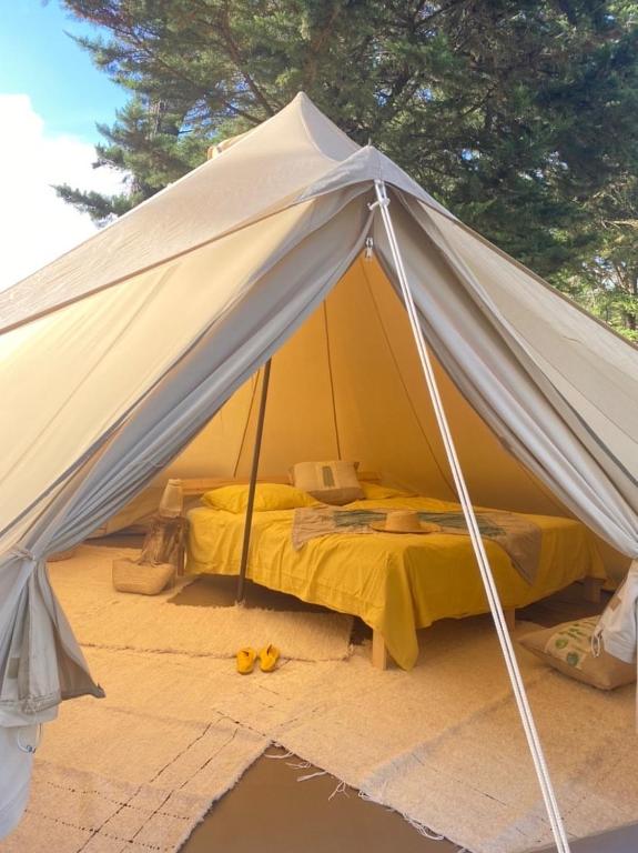 a white tent with a bed in it at Tipi le rocher couple 600m plage in Longeville-sur-Mer