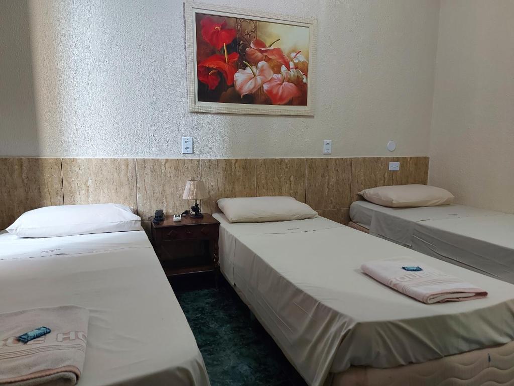 Habitación con 2 camas y una pintura en la pared. en Parque Hotel, en Río de Janeiro