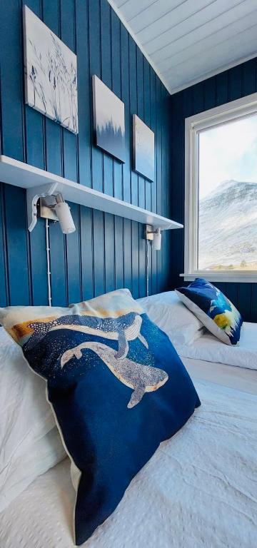 a bedroom with a whale pillow on a bed at Langahlid Cottages & Hot Tubs in Seyðisfjörður