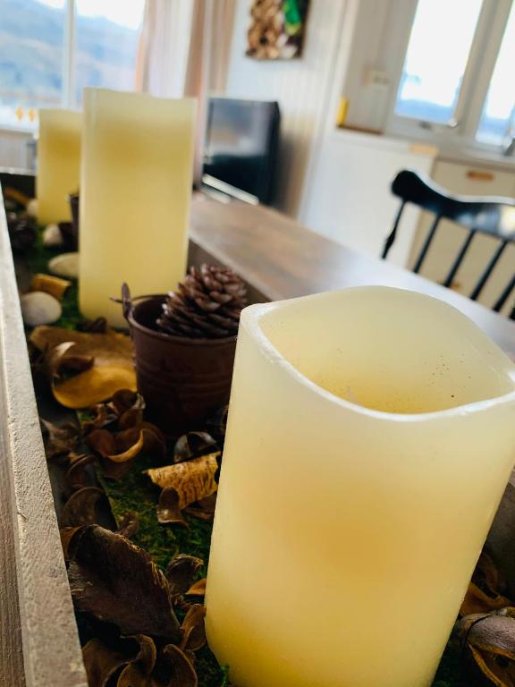 a table with two candles and a cup of coffee at Langahlid Cottages & Hot Tubs in Seyðisfjörður