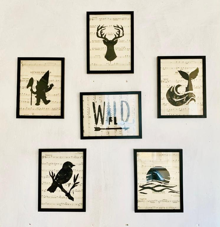 a group of framed pictures on a wall at Langahlid Cottages & Hot Tubs in Seyðisfjörður