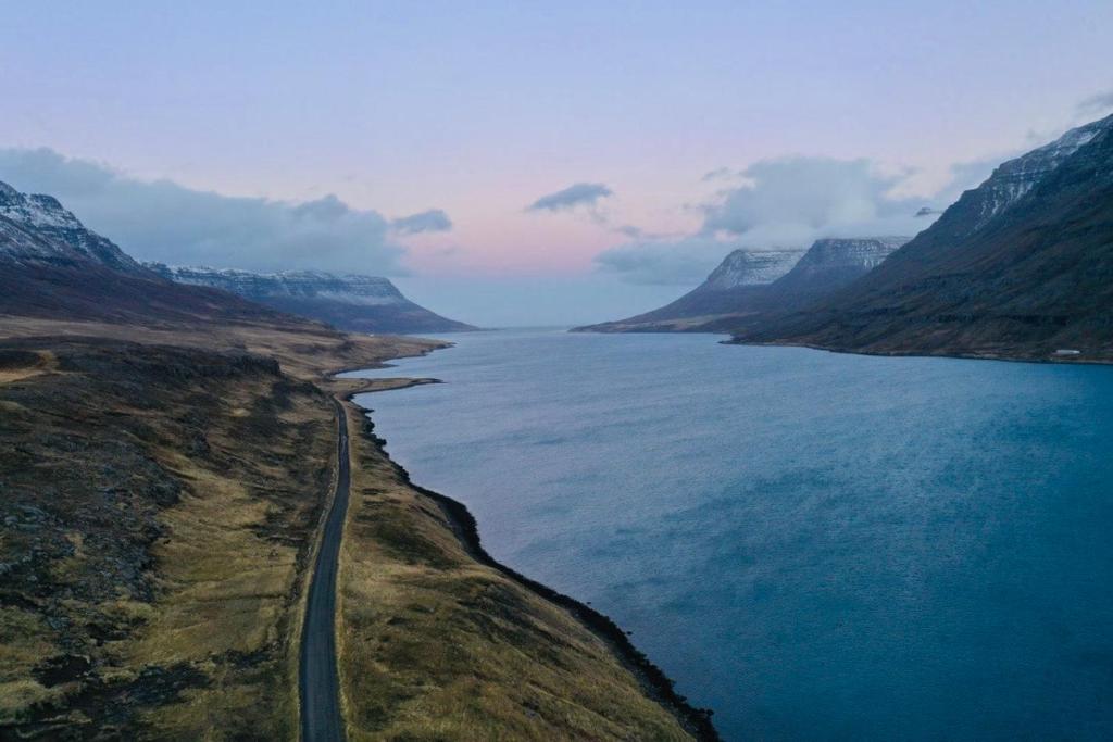 an aerial view of a road next to a body of water at Langahlid Cottages & Hot Tubs in Seyðisfjörður