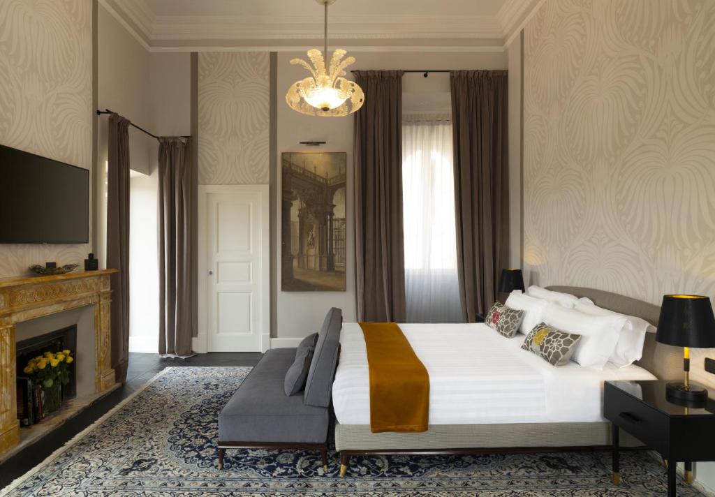 - une chambre avec un grand lit et un lustre dans l'établissement Ricciardelli Luxury Studios - Piazza di Spagna, à Rome