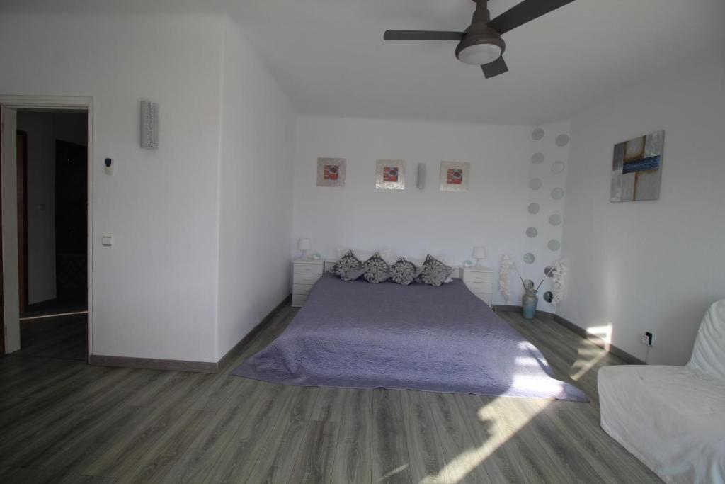 a bedroom with a bed and a ceiling fan at Casa do Milho in Carvoeiro
