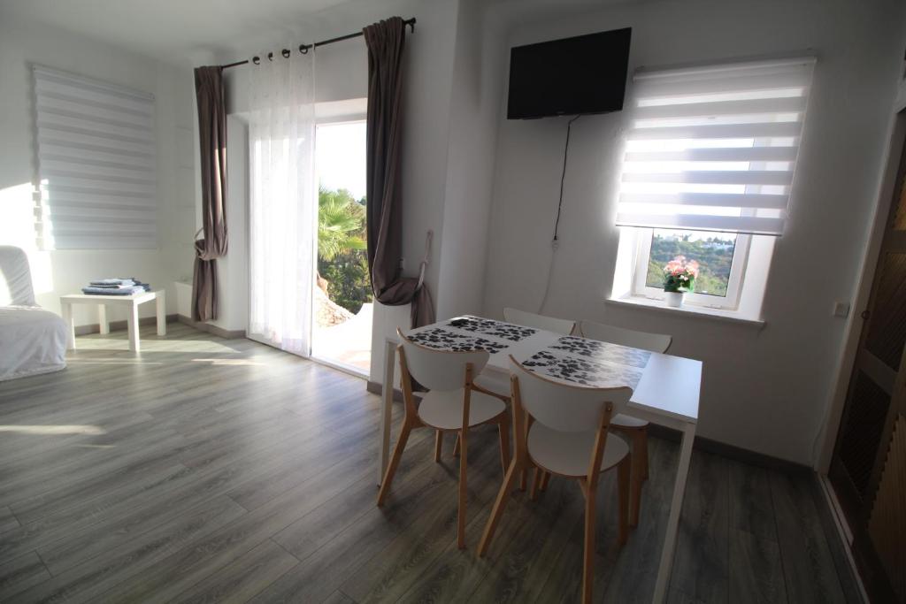 a room with a table and chairs and a window at Casa do Milho in Carvoeiro