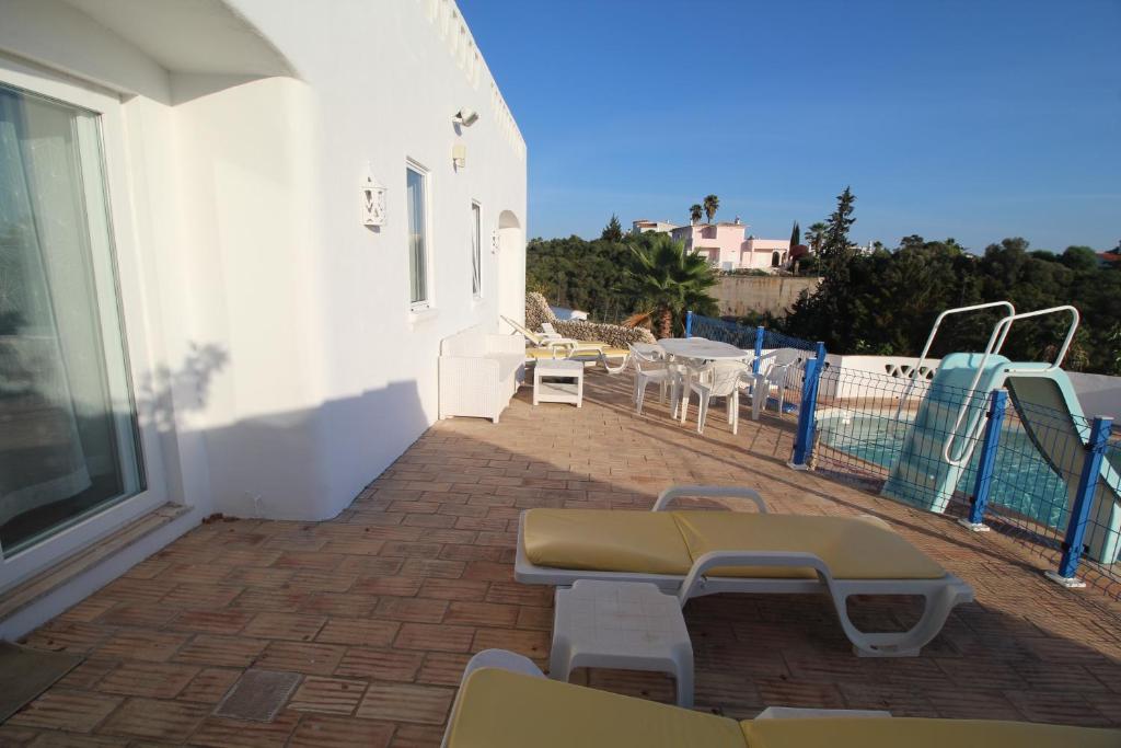 a patio with chairs and tables on a building at Casa do Milho in Carvoeiro