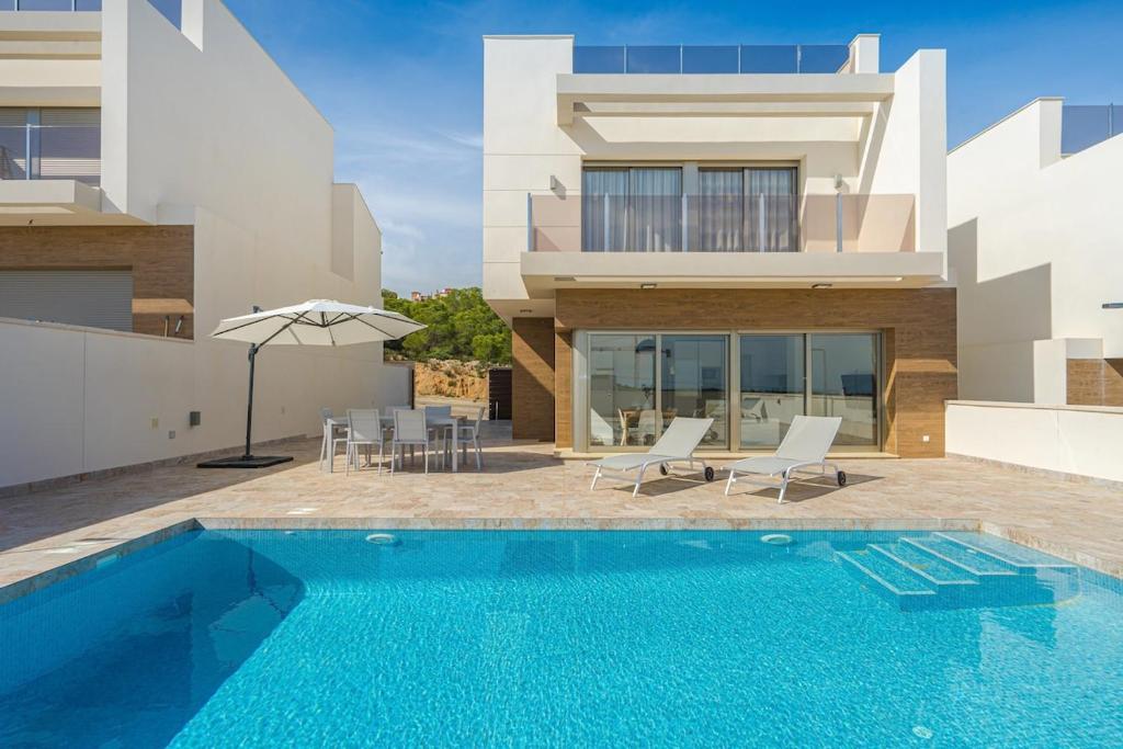 a swimming pool in front of a house at Iris in San Miguel de Salinas