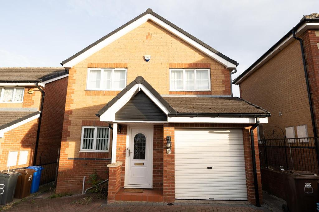 a brick house with a white garage at Longley Farm View -spacious 4 Bed Property in Sheffield