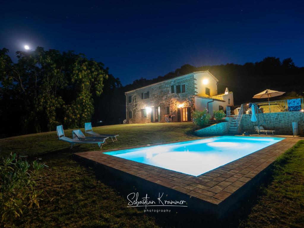 a swimming pool in front of a house at night at Casa Brizzi in San Pietro