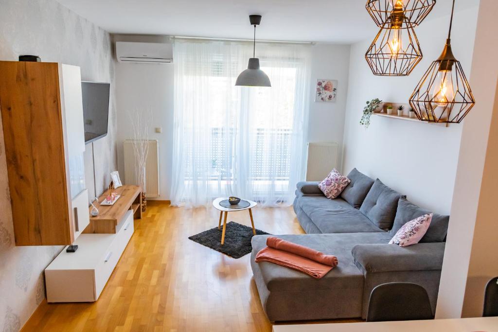 een woonkamer met een bank en een tafel bij BRAND NEW - SelfCheckIns 24 - Zagreb - Garage - Loggia - New - Luxury in Zagreb
