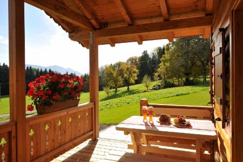 eine Holzterrasse mit einer Bank und Blick auf ein Feld in der Unterkunft Lamplhof in Rimsting