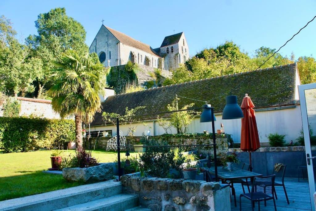 - une terrasse avec une table et un parasol dans l'établissement Le repaire, agréable logement, vue imprenable, à Rochefort-en-Yvelines