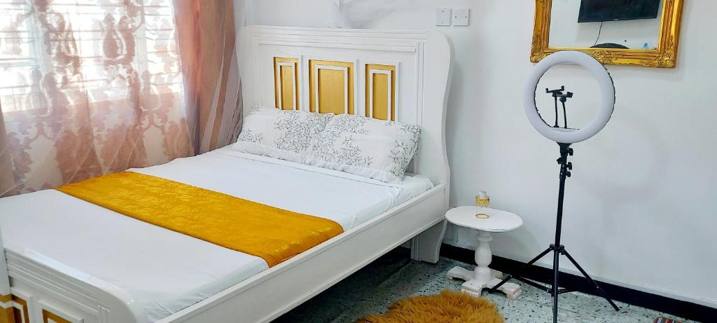 a small bedroom with a bed and a mirror at Neighbourly Nest in Mombasa