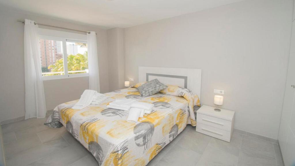 ein weißes Schlafzimmer mit einem Bett und einem Fenster in der Unterkunft Turmalina 35c in Calpe