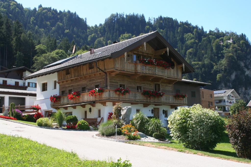 a house in the mountains with flowers on the balconies at Appartement Kichelerhof in Strass im Zillertal