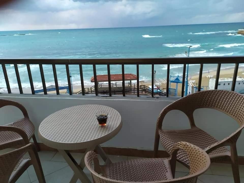 a balcony with a table and chairs and the ocean at شقةعلى البحرمباشرةسيدي بشرالمربع الذهبي in Alexandria