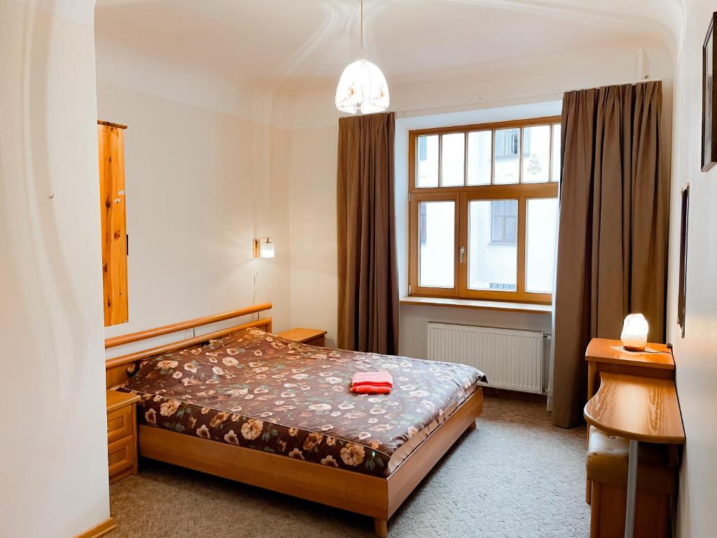 a small bedroom with a bed and a window at Terbatas Apartment in Rīga