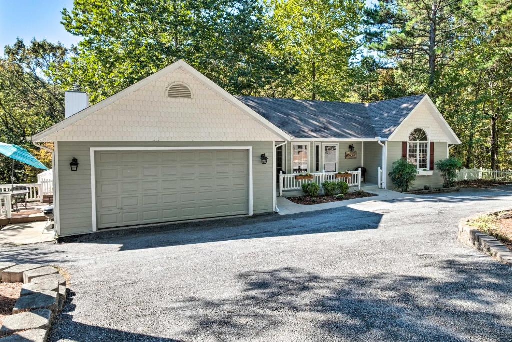 una casa con garaje en una entrada en Beautiful Ozark Oasis with Deck Walk to Beaver Lake, en Rogers