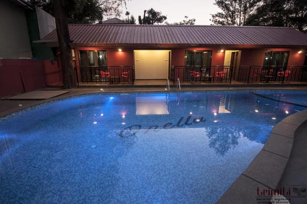 una gran piscina azul frente a una casa en ONELLA REGENCY, en Panchgani