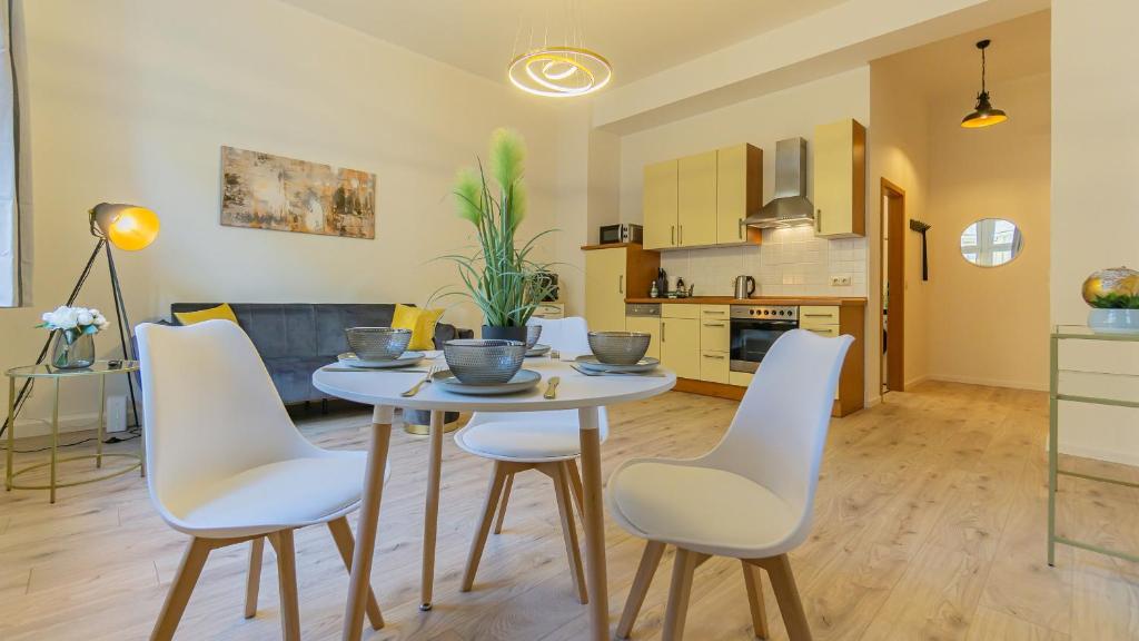 cocina y sala de estar con mesa y sillas en CityApartment - 53 m², 2 Zimmer, zentral, Netflix, Küche, Waschmaschine, en Cottbus