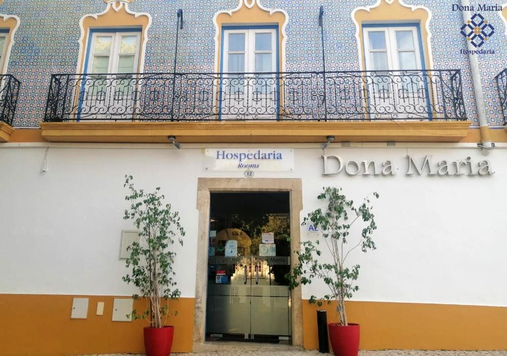 a store with a balcony on a building at Hospedaria Dona Maria in Beja