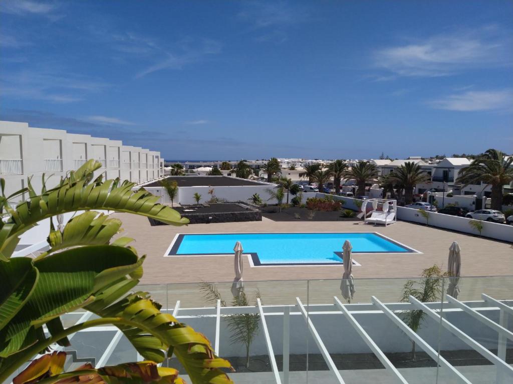 vista sulla piscina di un resort di Apartment Namaste- Amazing sea view & infinity pool - good Wifi - smart tv-Residence Senator a Costa Teguise