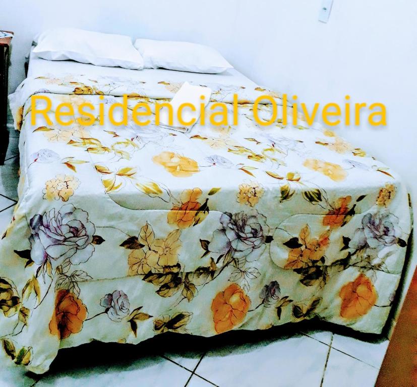 Una cama con una manta con flores. en RESIDENCIAL OLIVEIRA, en Manaus
