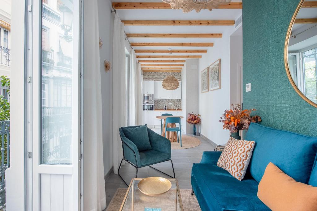 a living room with a blue couch and a table at Lukanda Luxury in Seville