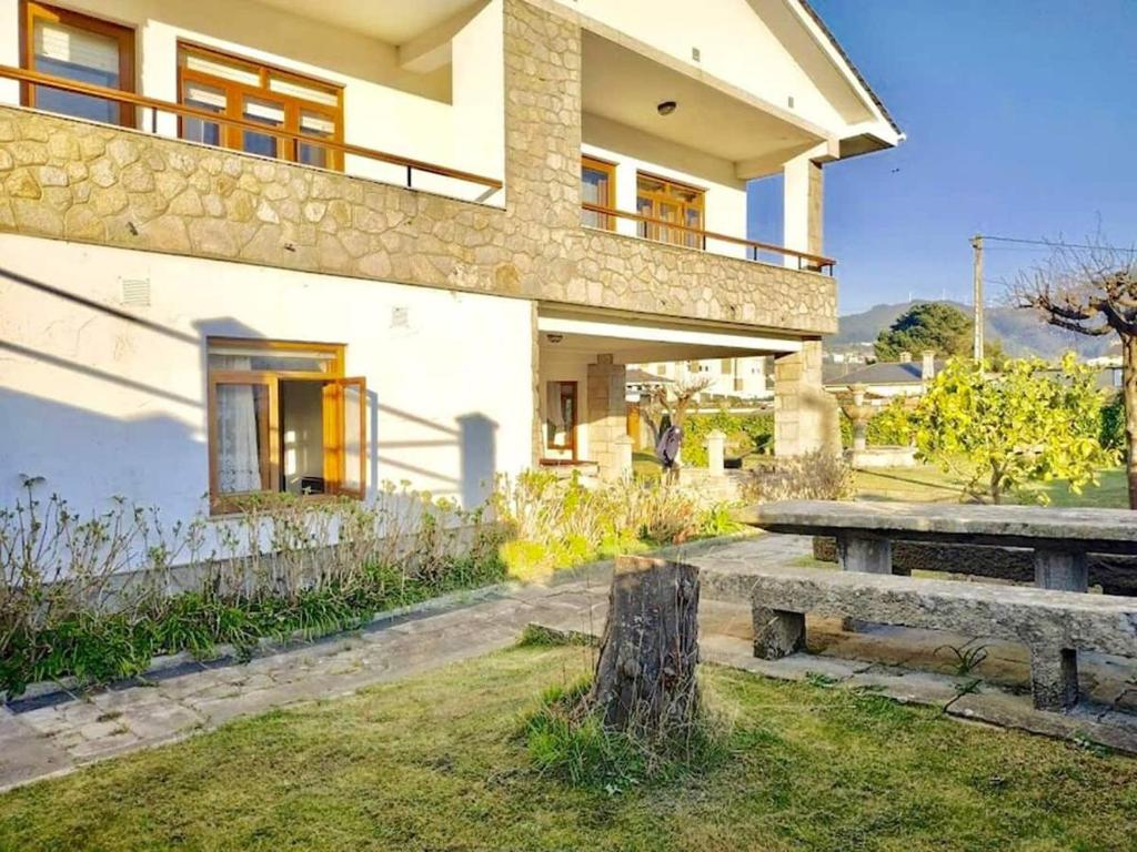 dom ze stołem piknikowym przed nim w obiekcie Covas Beach Garden w mieście Viveiro