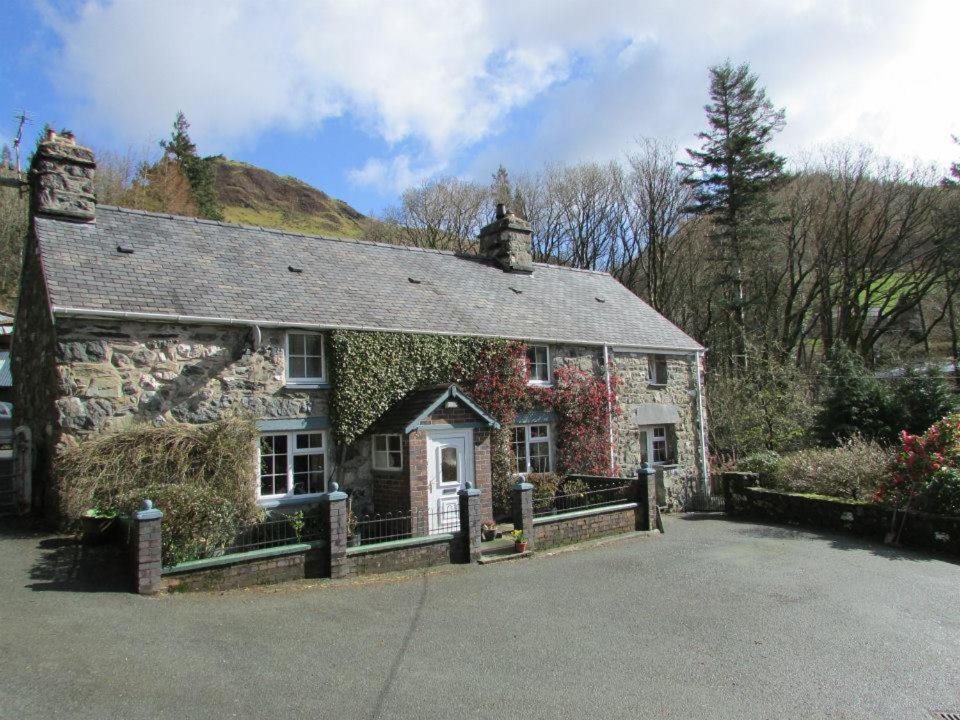 una vieja casa de piedra con hiedra creciendo en ella en Bryn Sion Farm, en Dinas Mawddwy