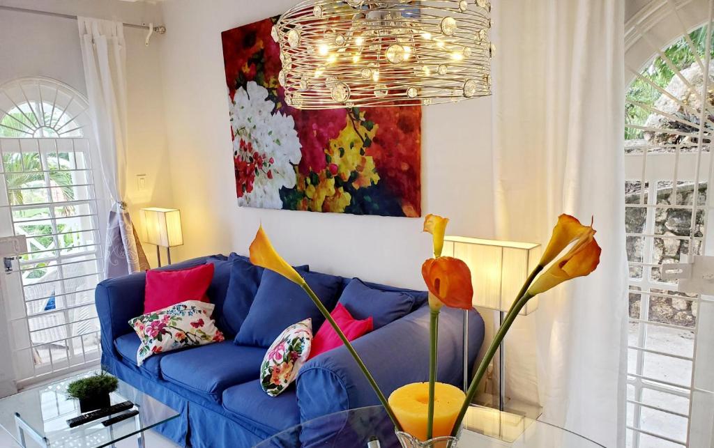 a blue couch in a living room with a painting at Emerald Garden in Ocho Rios