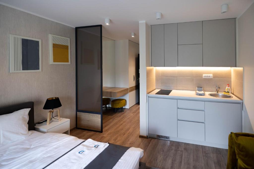 a bedroom with a bed and a bathroom with a sink at Omega Apartments in Vrnjačka Banja